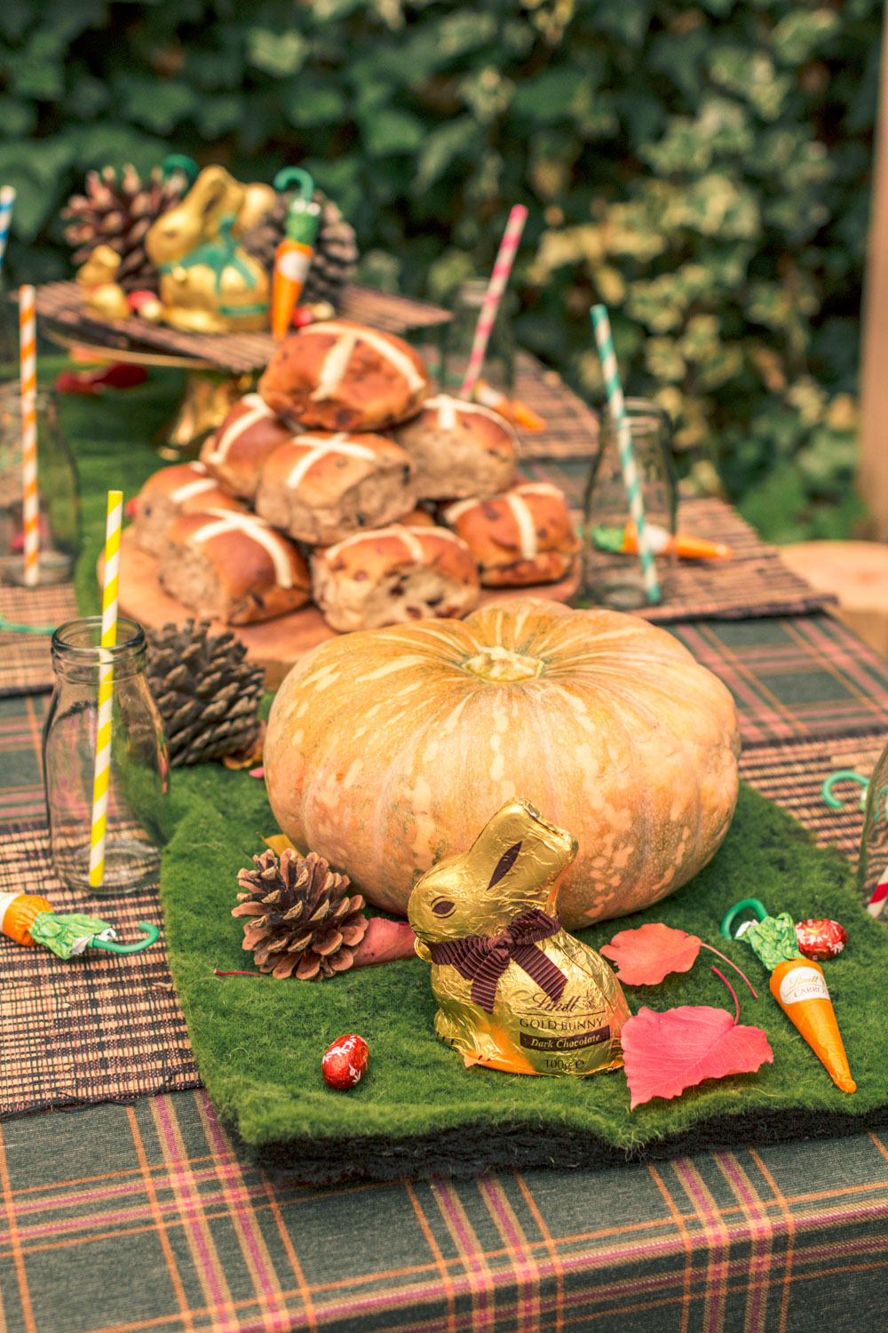 Autumn Easter Egg Hunt Childrens Table decorated with Pumpkins, pinecones, chocolate bunnies, chocolate carrots, mini milk bottles and hot cross buns