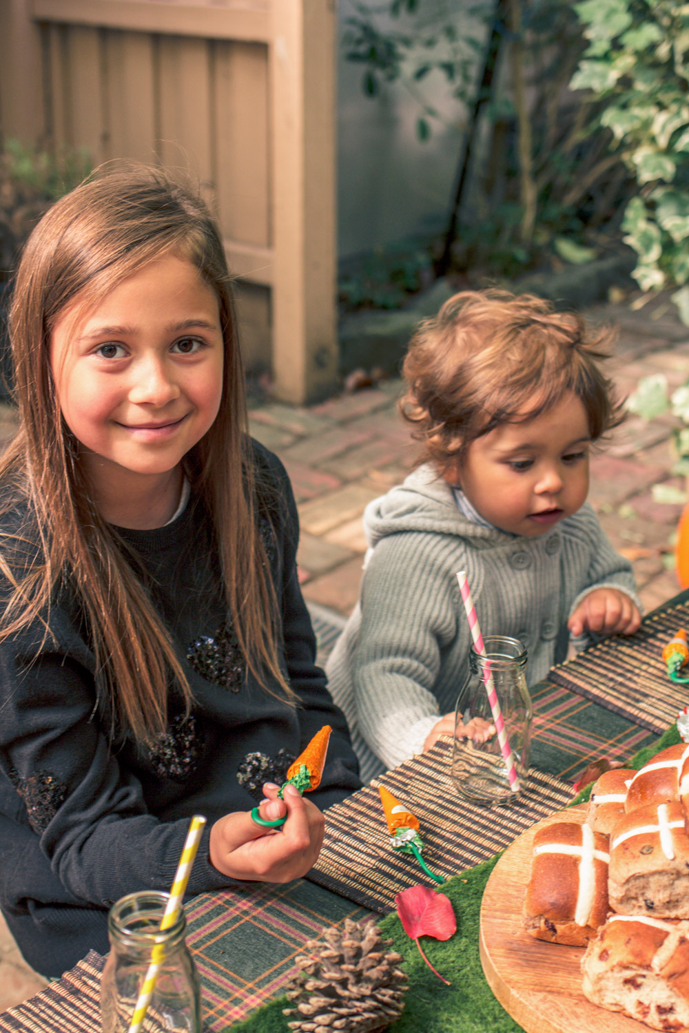 Kids eating chocolate carrots seated at party table at Autumn Easter Egg Hunt