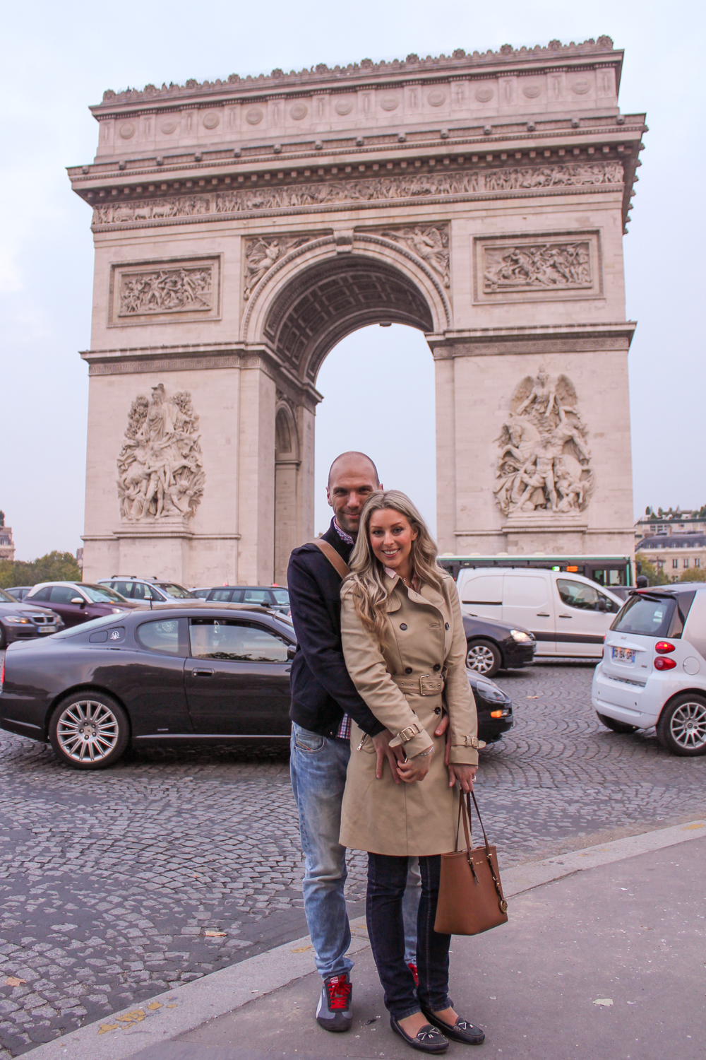 Deneale from Goldfields Girl wearing trench coat and Michael Kors bag in Paris Arc du Triumph