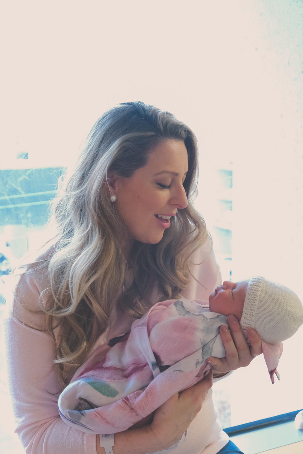 Goldfields Girl sitting in hospital window with new baby surrounded by flowers and cards