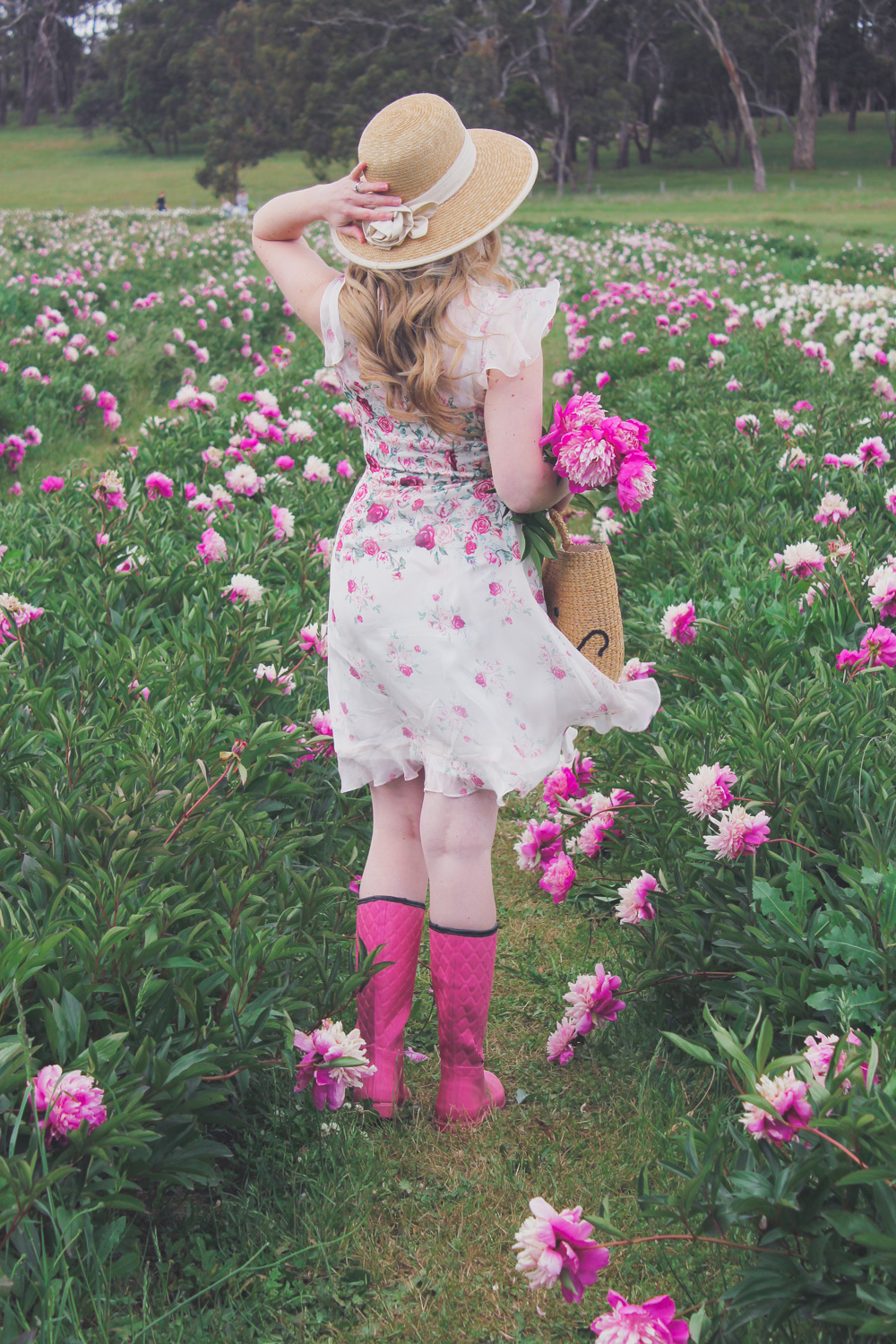 Goldfields Girl standing in the Peony Paddock at Spring Hill Peony Farm wearing an Alannah Hill dress and straw hat