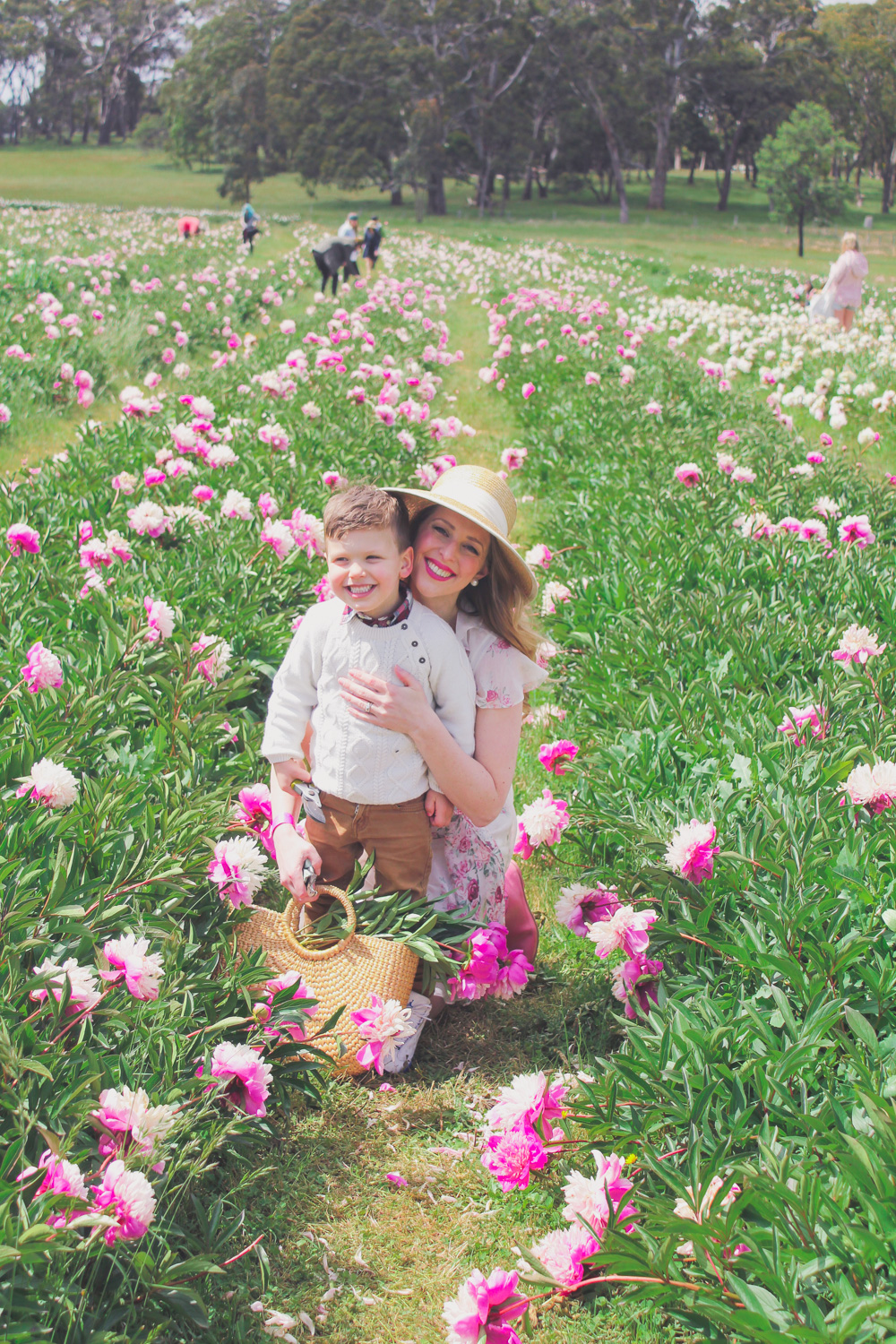 Goldfields Girl standing in the Peony Paddock at Spring Hill Peony Farm wearing an Alannah Hill dress and straw hat