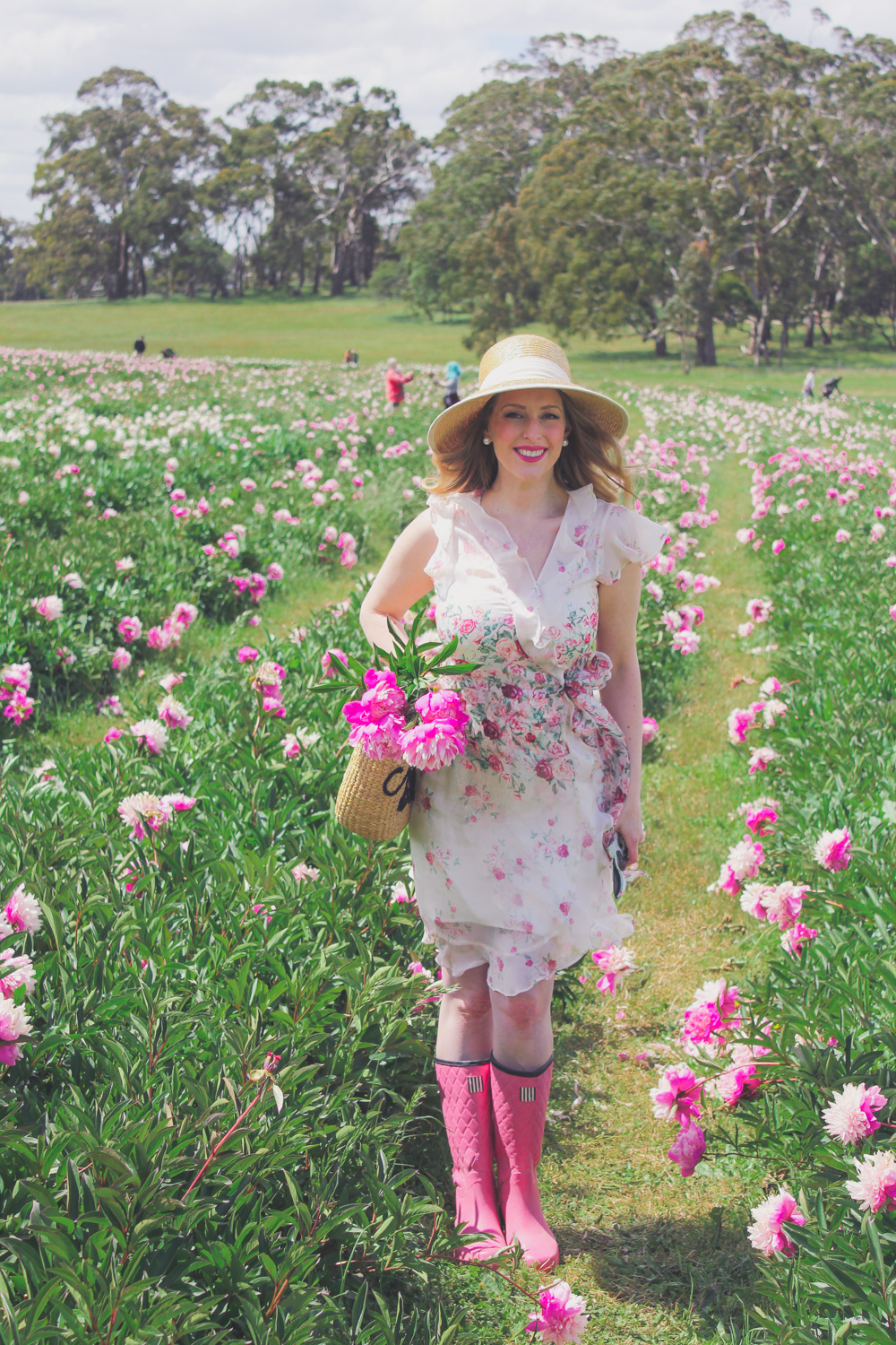 Goldfields Girl standing in the Peony Paddock at Spring Hill Peony Farm wearing an Alannah Hill dress and straw hat