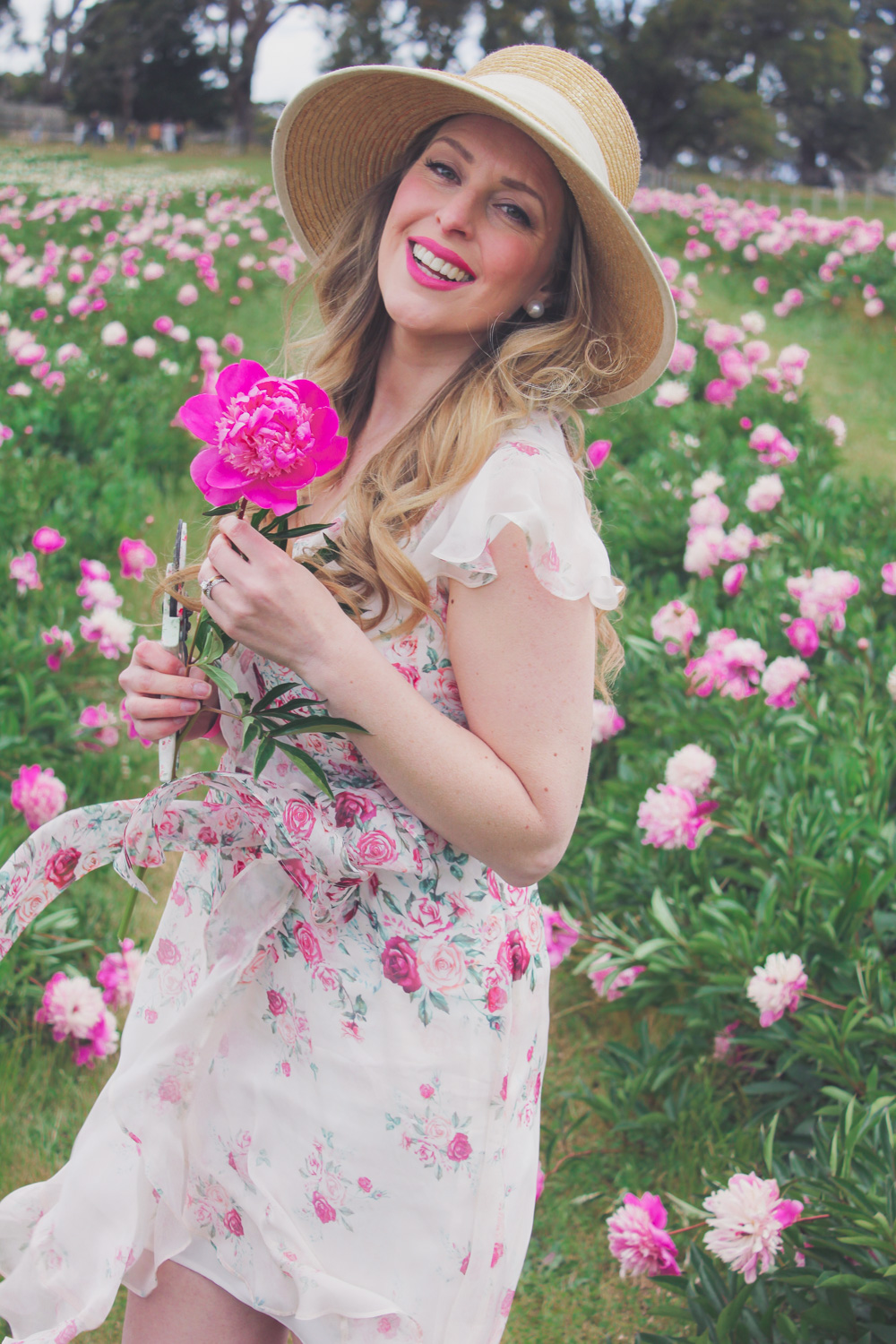 Goldfields Girl standing in the Peony Paddock at Spring Hill Peony Farm wearing an Alannah Hill dress and straw hat