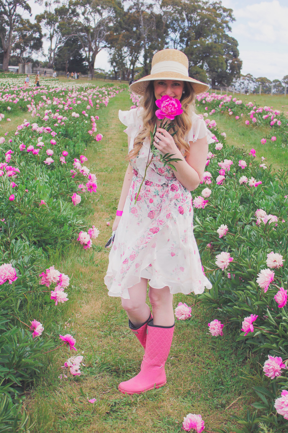 Goldfields Girl standing in the Peony Paddock at Spring Hill Peony Farm wearing an Alannah Hill dress and straw hat