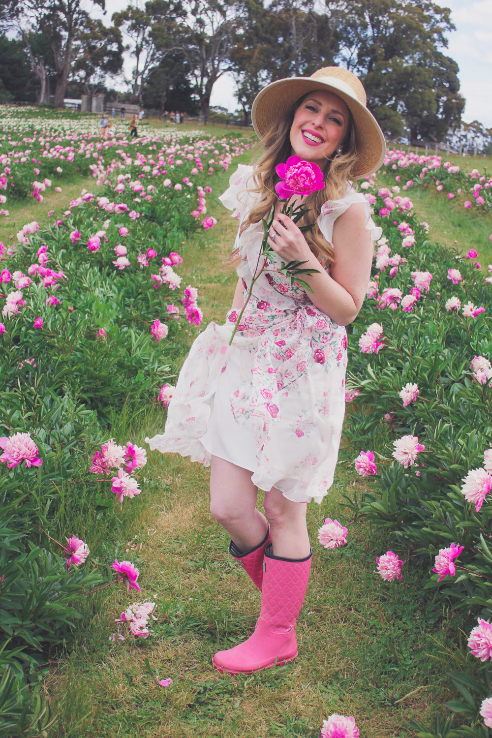 Goldfields Girl standing in the Peony Paddock at Spring Hill Peony Farm wearing an Alannah Hill dress and straw hat