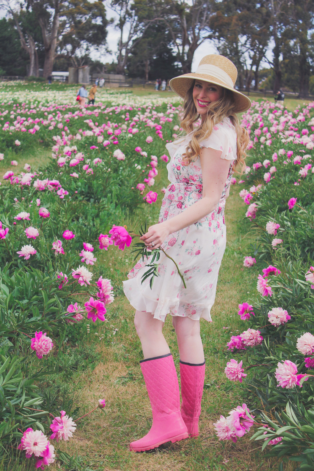 Goldfields Girl standing in the Peony Paddock at Spring Hill Peony Farm wearing an Alannah Hill dress and straw hat