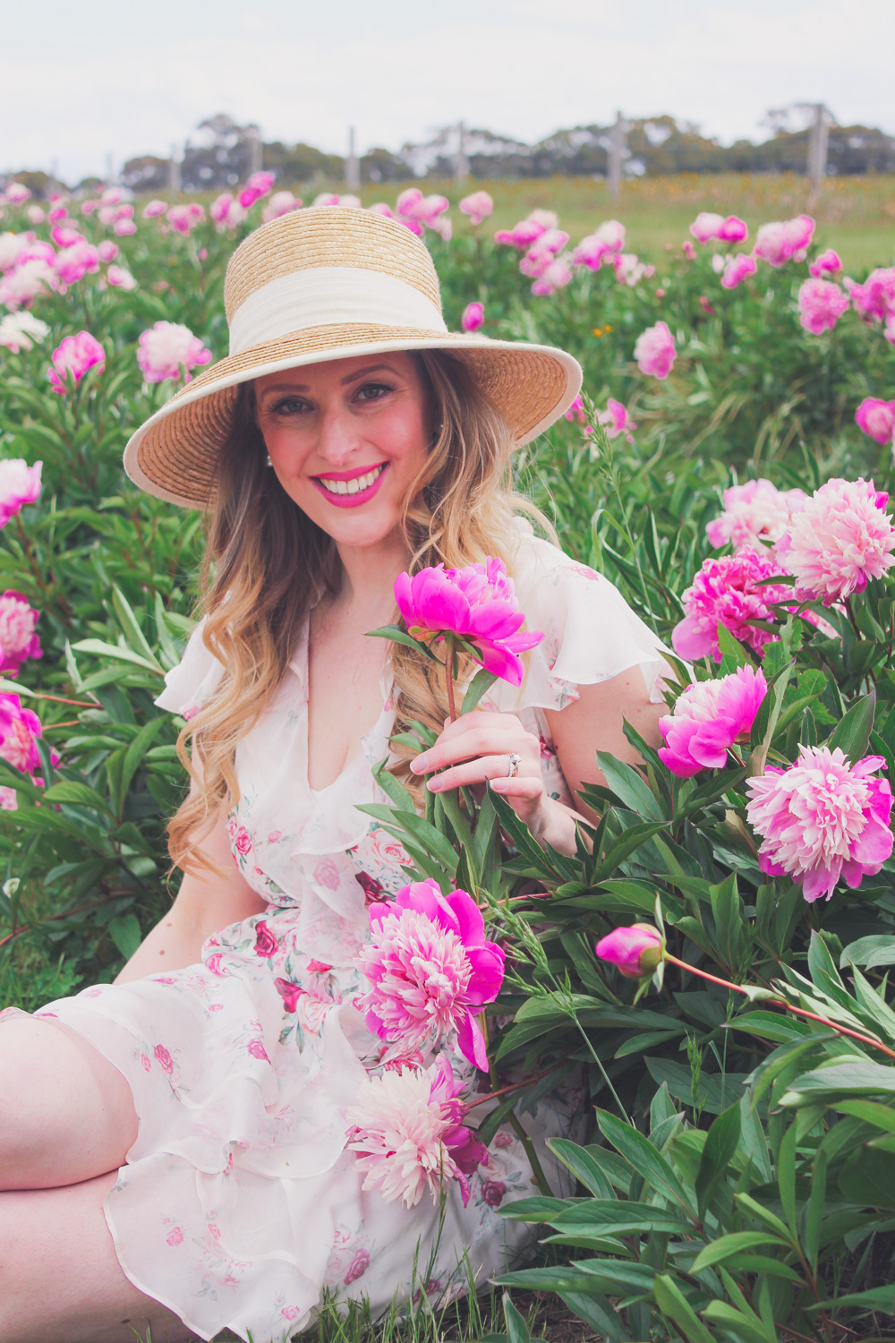 Goldfields Girl standing in the Peony Paddock at Spring Hill Peony Farm wearing an Alannah Hill dress and straw hat