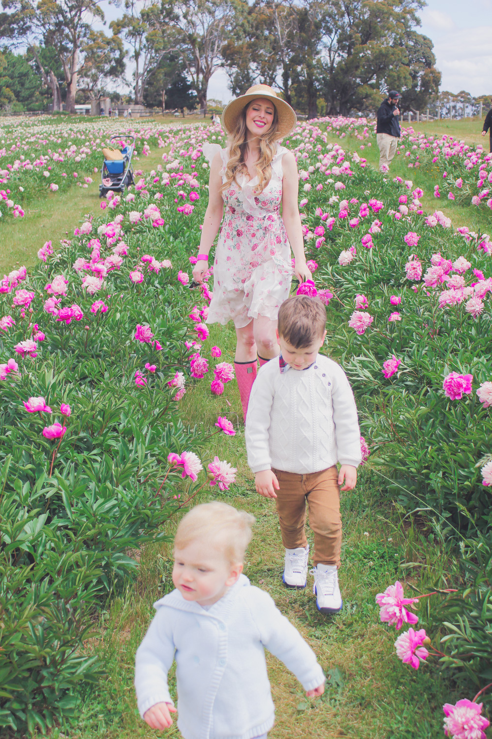 Goldfields Girl standing in the Peony Paddock at Spring Hill Peony Farm wearing an Alannah Hill dress and straw hat