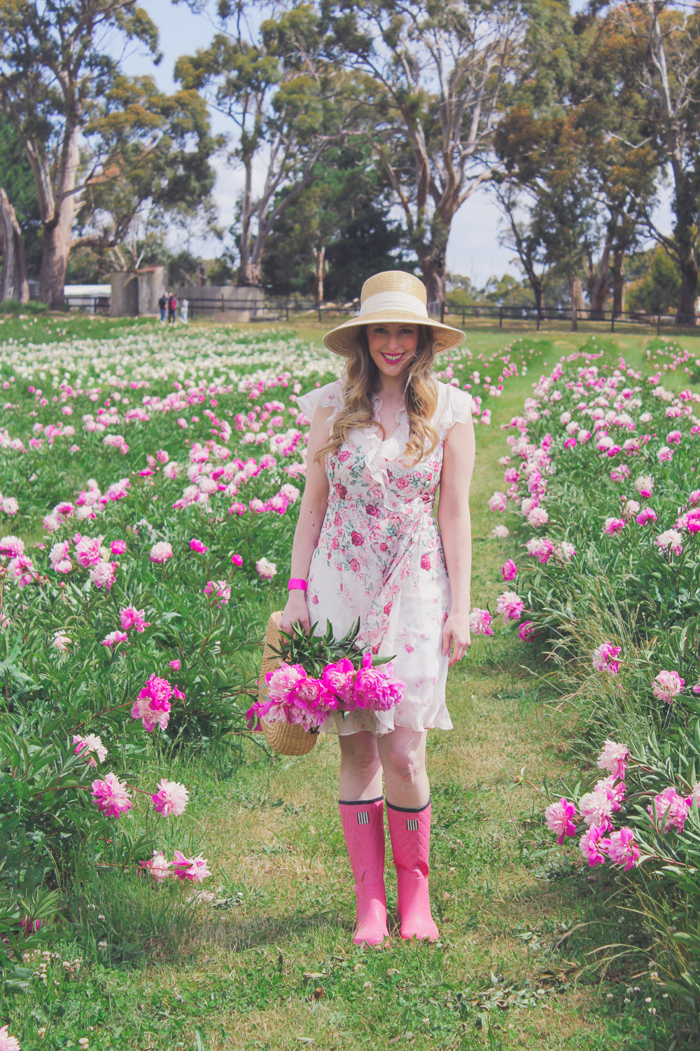 Goldfields Girl standing in the Peony Paddock at Spring Hill Peony Farm wearing an Alannah Hill dress and straw hat