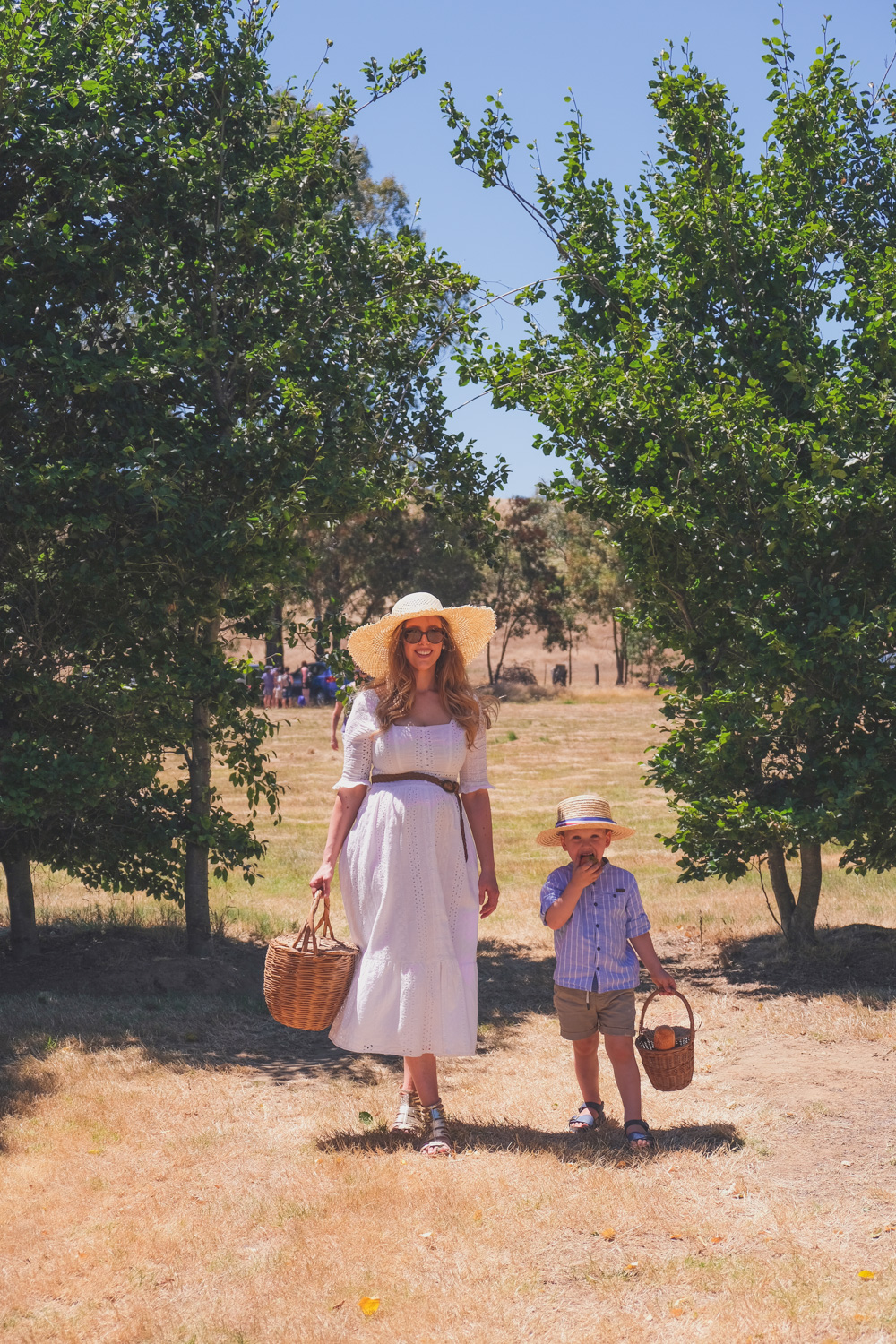 Goldfields Girl and family wearing white summer maternity dress and straw hat at the Harvest Festival at Lavandula Lavender Farm in Daylesford