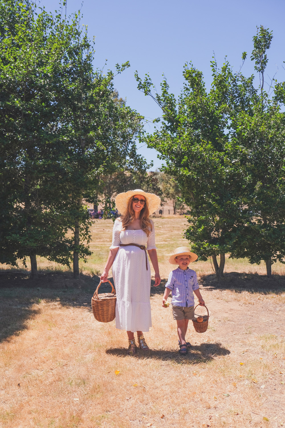 Goldfields Girl and family wearing white summer maternity dress and straw hat at the Harvest Festival at Lavandula Lavender Farm in Daylesford