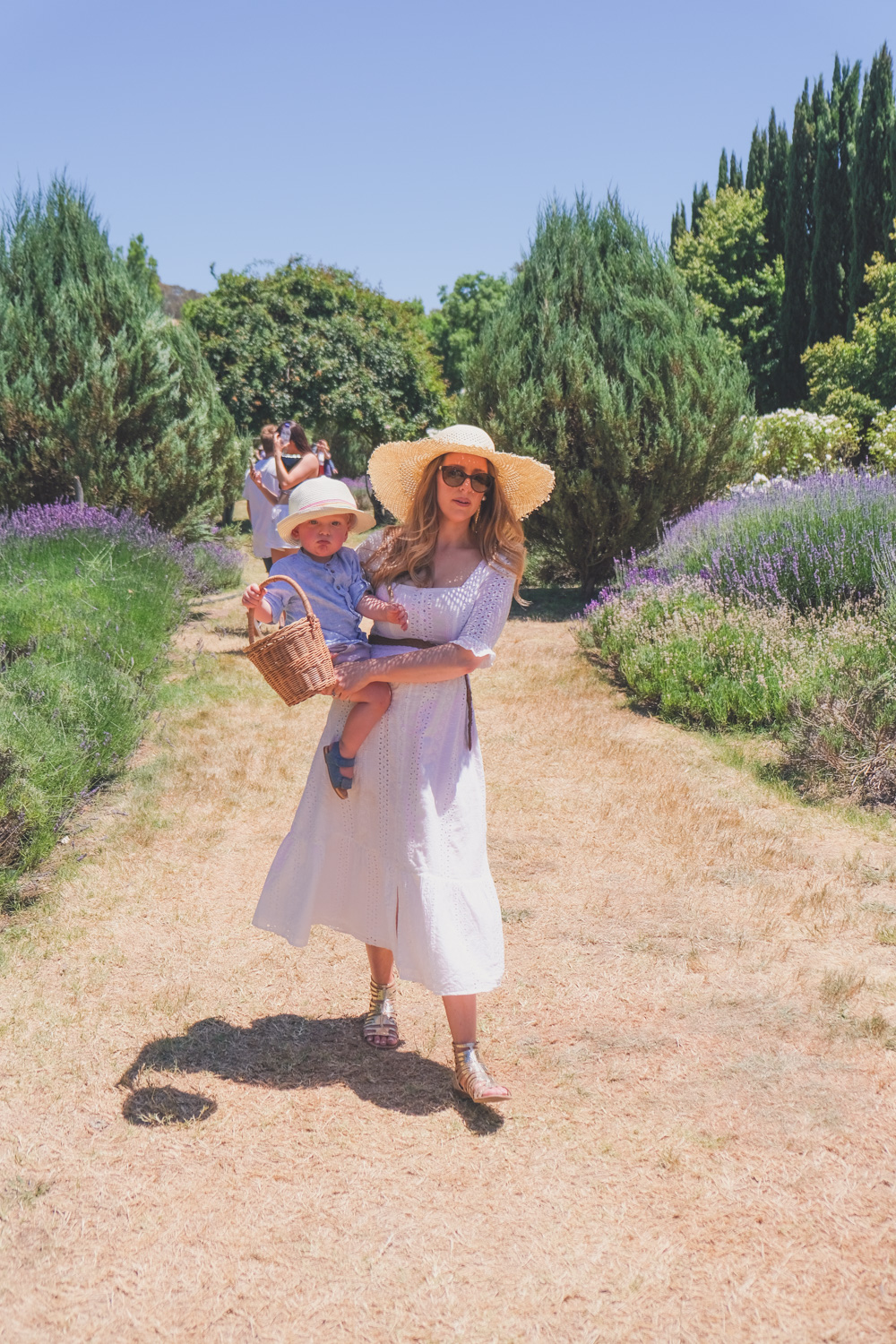 Goldfields Girl and family wearing white summer maternity dress and straw hat at the Harvest Festival at Lavandula Lavender Farm in Daylesford