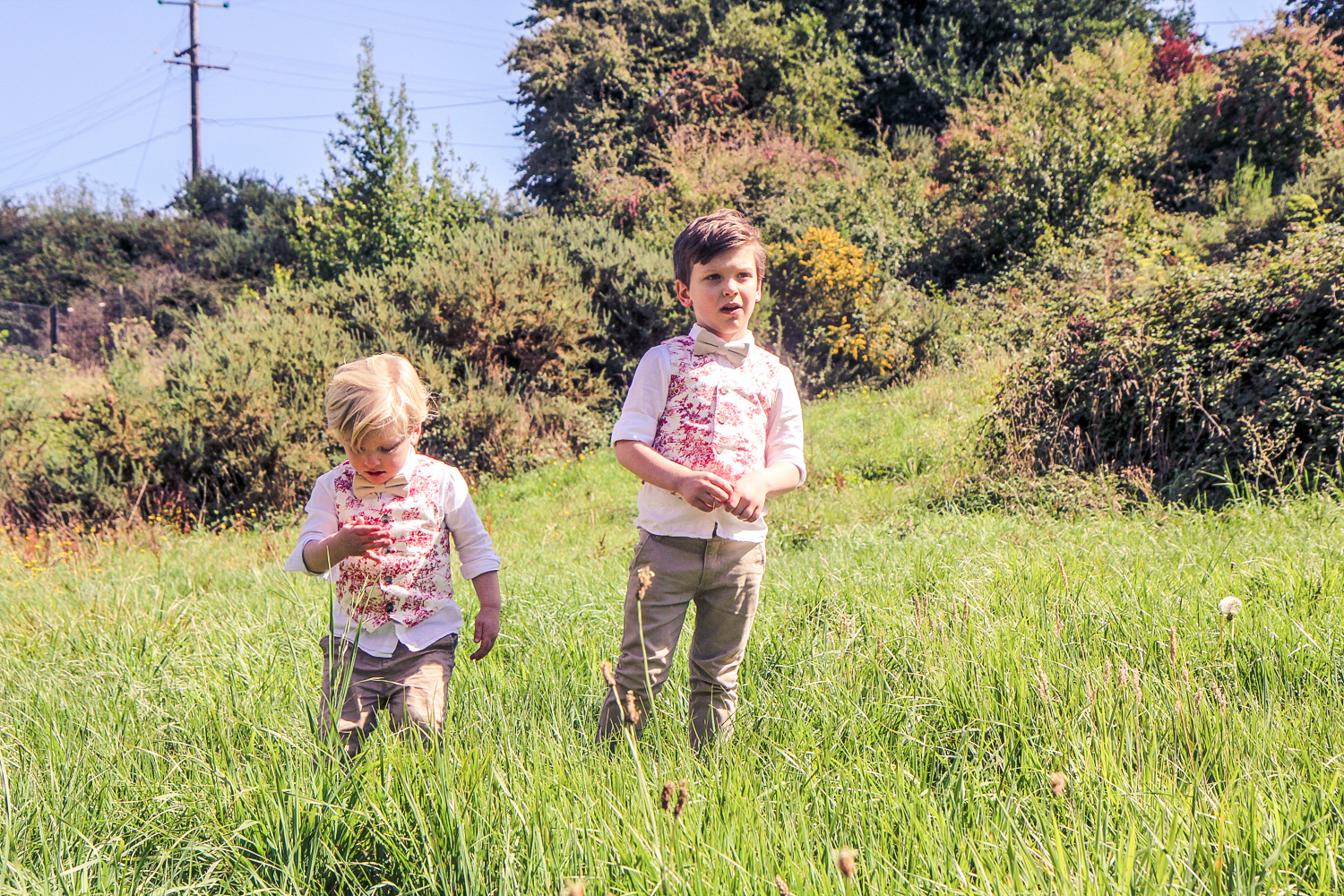 Little boys wearing matching bow ties and Janie and Jack red toile vests