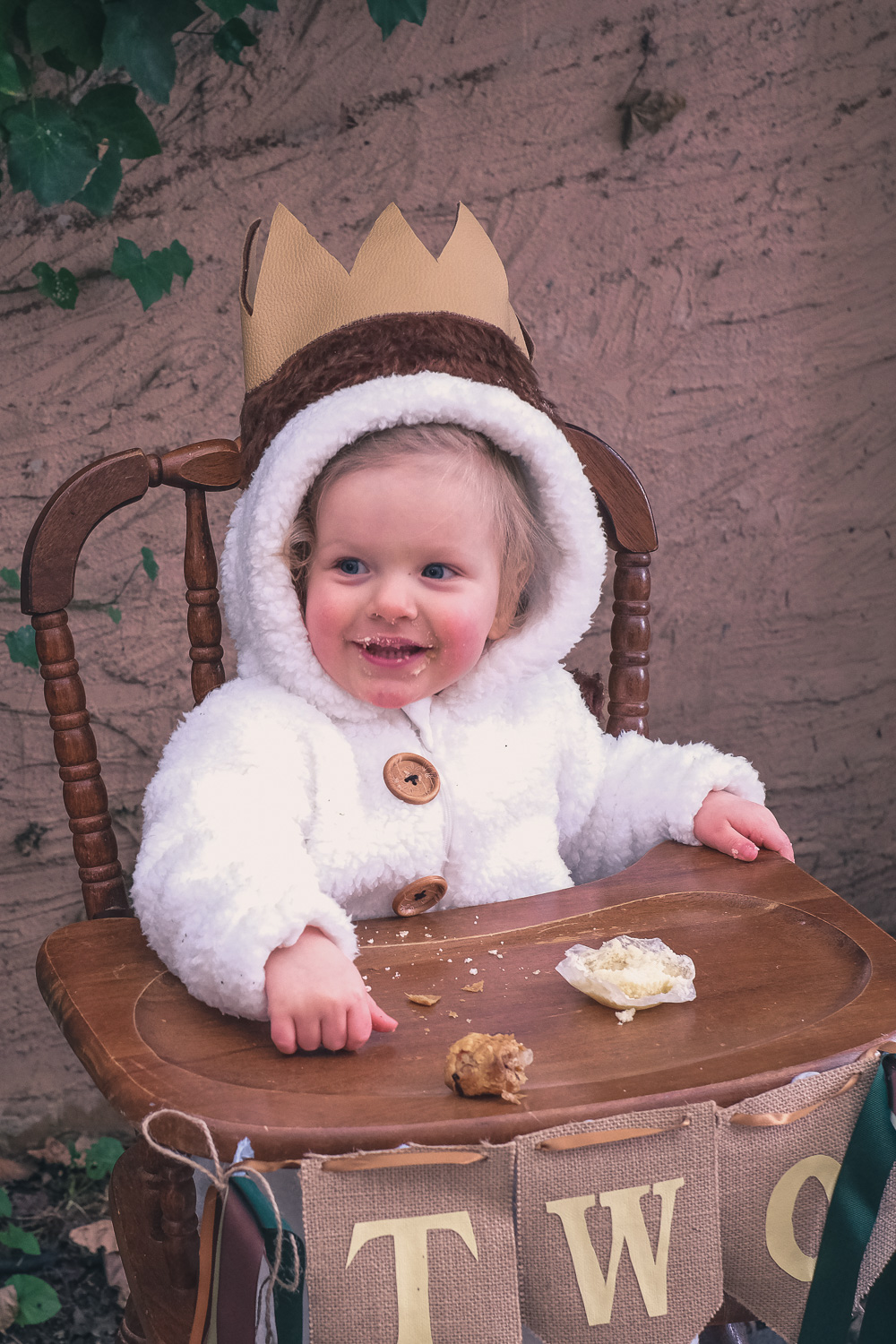 Child wearing Where The Wild Things Are party costume sits in a vintage high chair